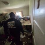 Rapid Junk Pros crew member walking into a cluttered room at the start of a cleanout