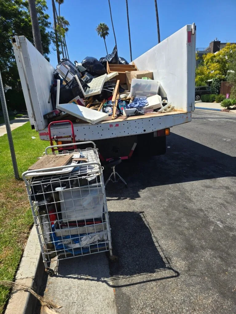 Packing vs. Purging: What Movers Wish You Knew Before Moving Day 4 movers hauling furniture during a packing vs purging sort